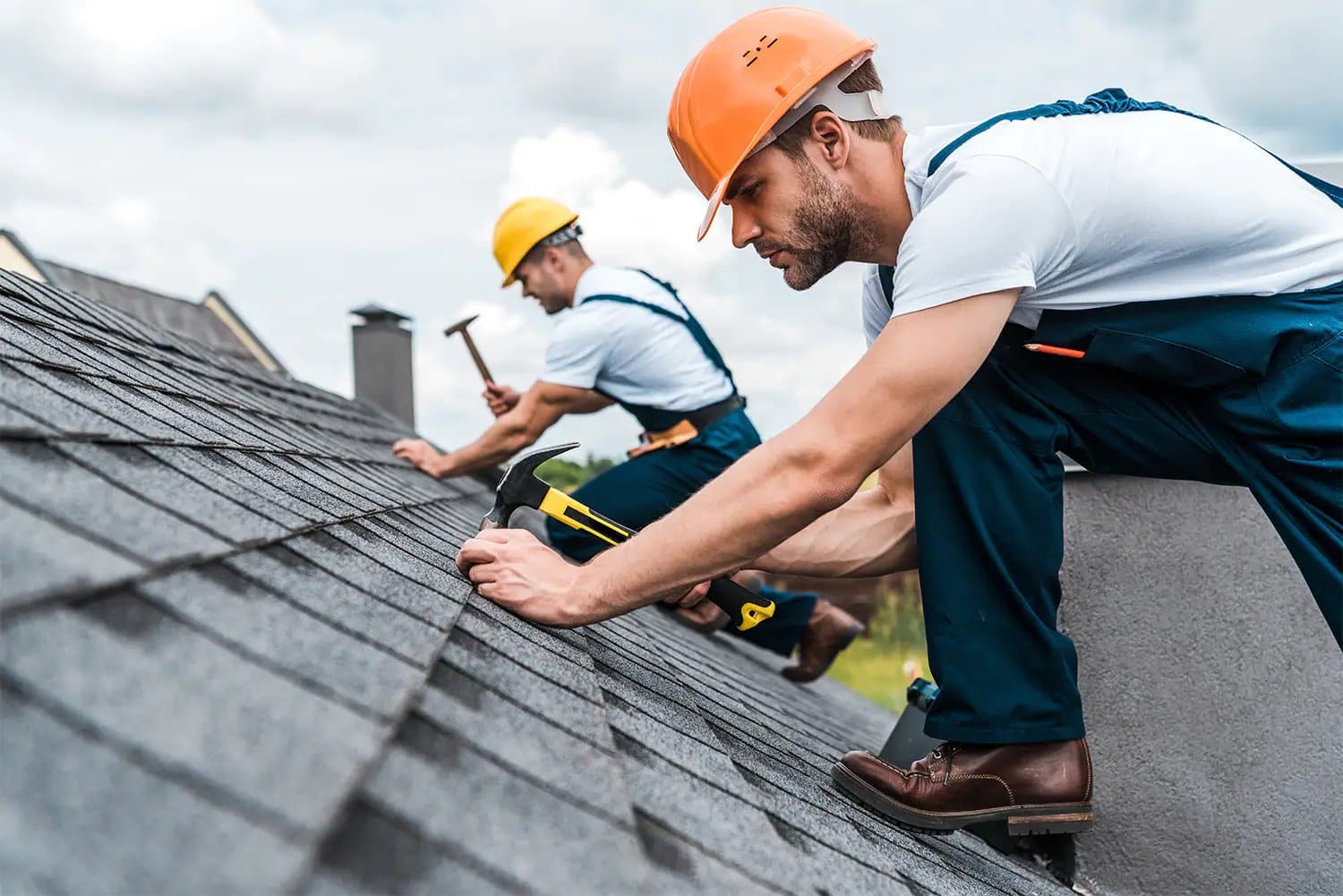 Guys hammering nails on a roof